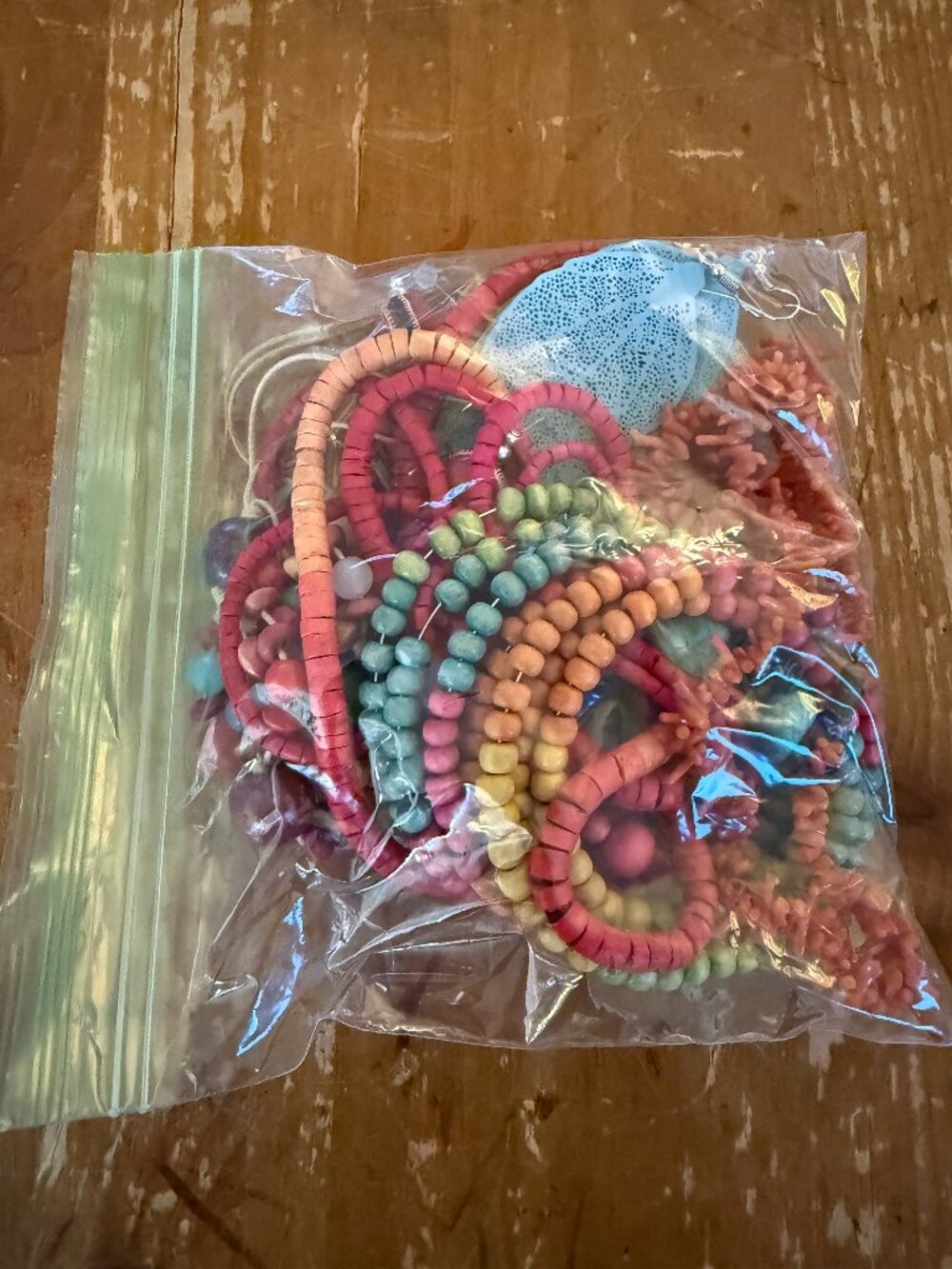 Assorted bag of colorful jewelry, includes bracelets, necklaces, wooden beads